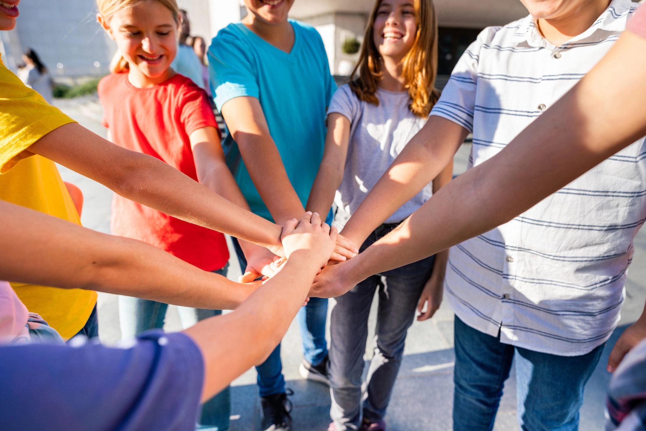 Young people standing together with hands joined, representing community and teamwork